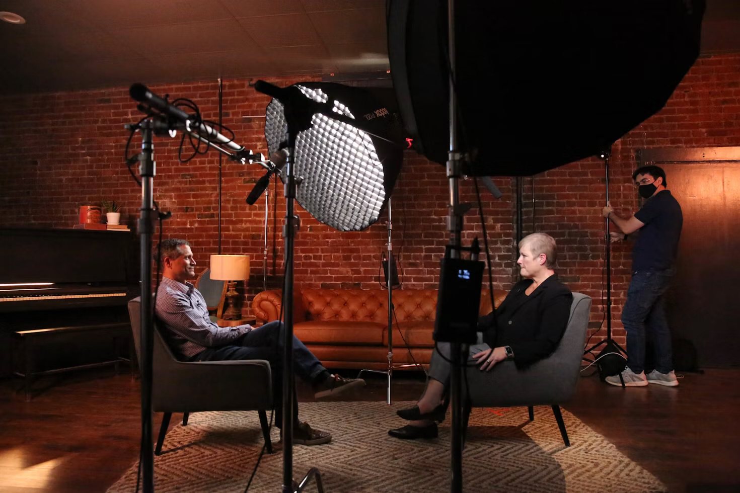 A Legacy Stories interview being filmed in a warm studio setting with professional lighting and microphones